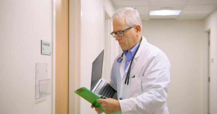 Doctor looking at charts in front of exam room