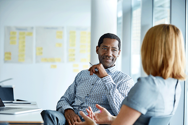 Business man speaking to woman in a conference room