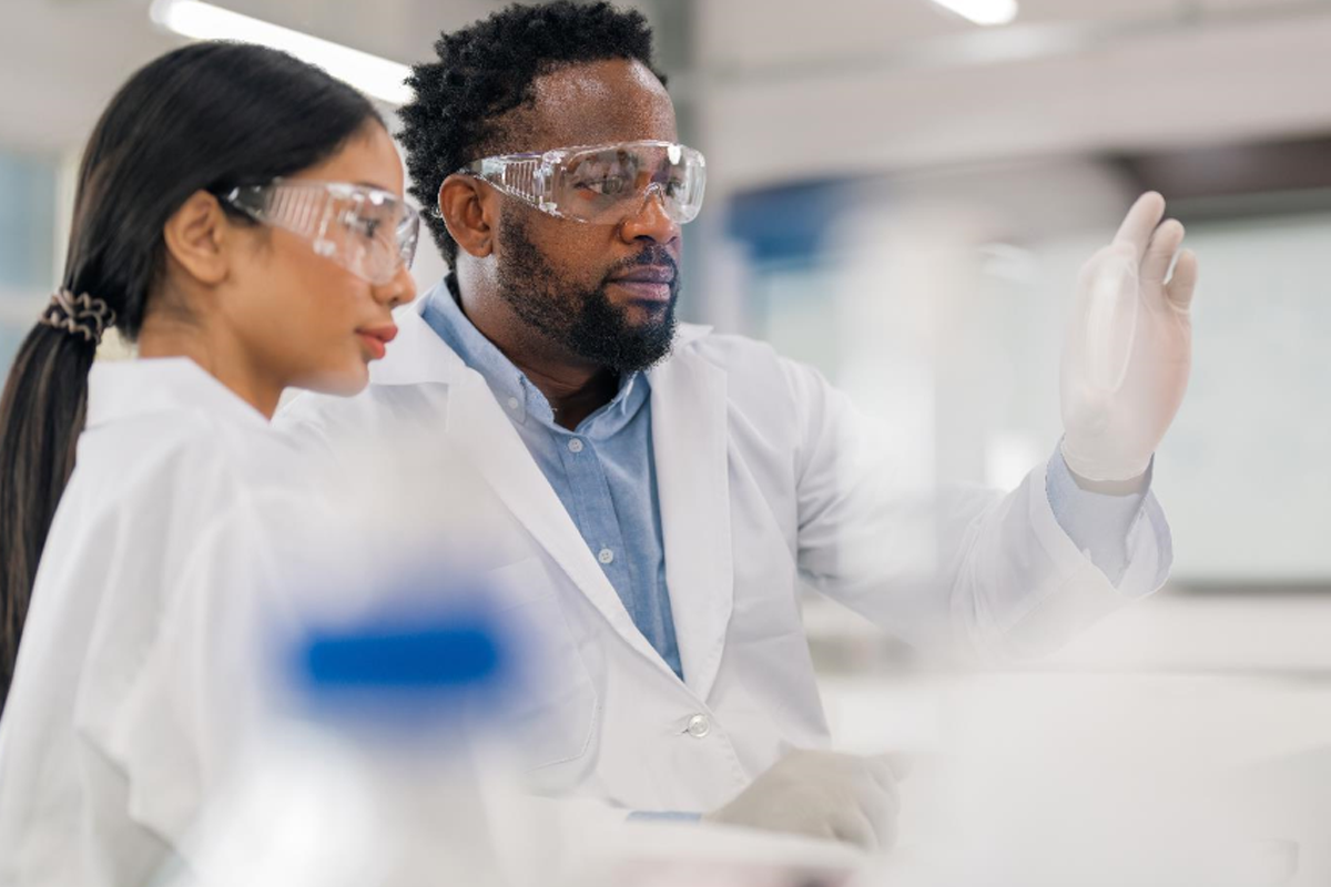 Two scientists working inside a lab observing a sample