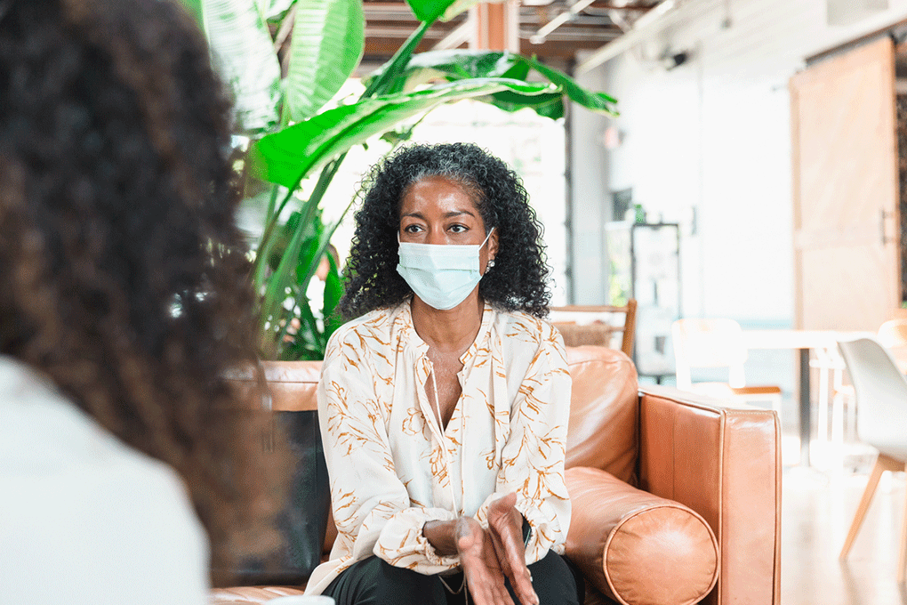 Patient sitting on a couch speaking to doctor